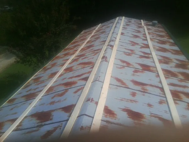 Rusted metal roof panels with new wood purlins before replacement — Storm Damage Roof Repair in Oxbow by Roofing Brothers