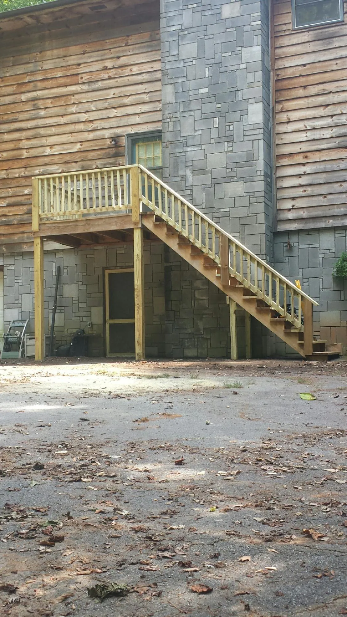 New pressure treated deck and stair landing on a log home in Oxbow