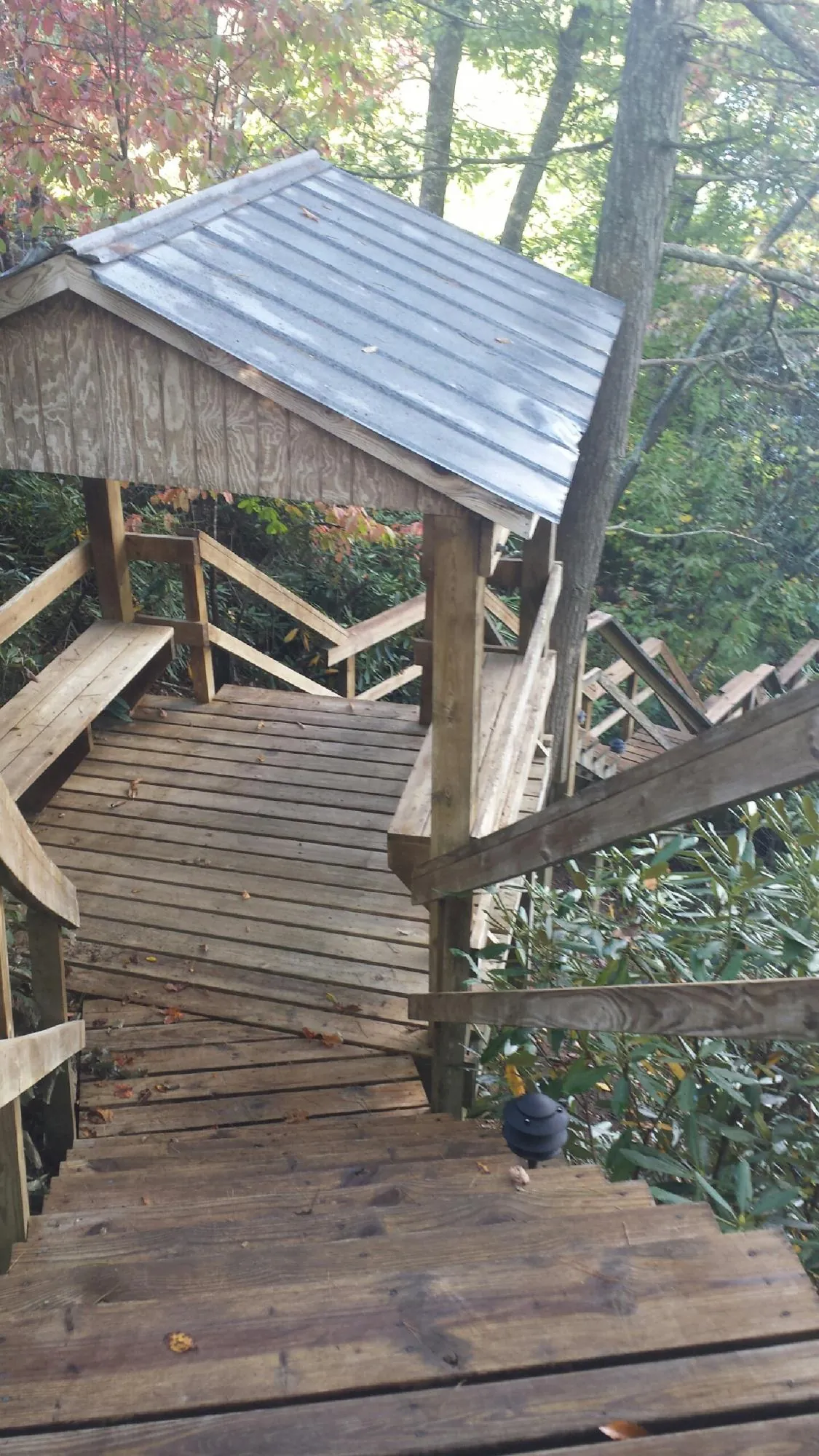 Metal roofed shelter over wooden steps on a wooded walkway — Skylight Repair & Installation work by our crew in Oxbow