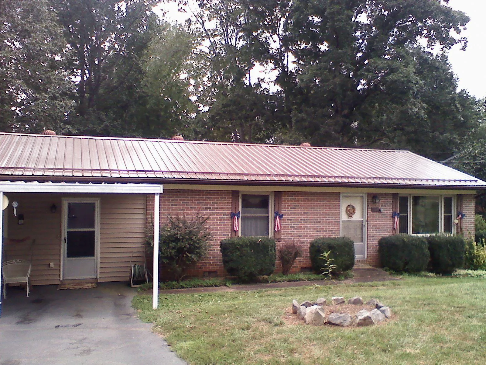 Bronze metal roof and carport on a brick ranch home — Roof Repair work by our crew in Oxbow